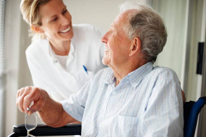 Elderly man speaking to a nurse