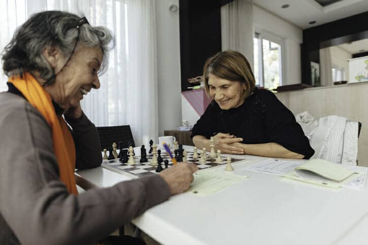 Cheerful senior woman playing chess