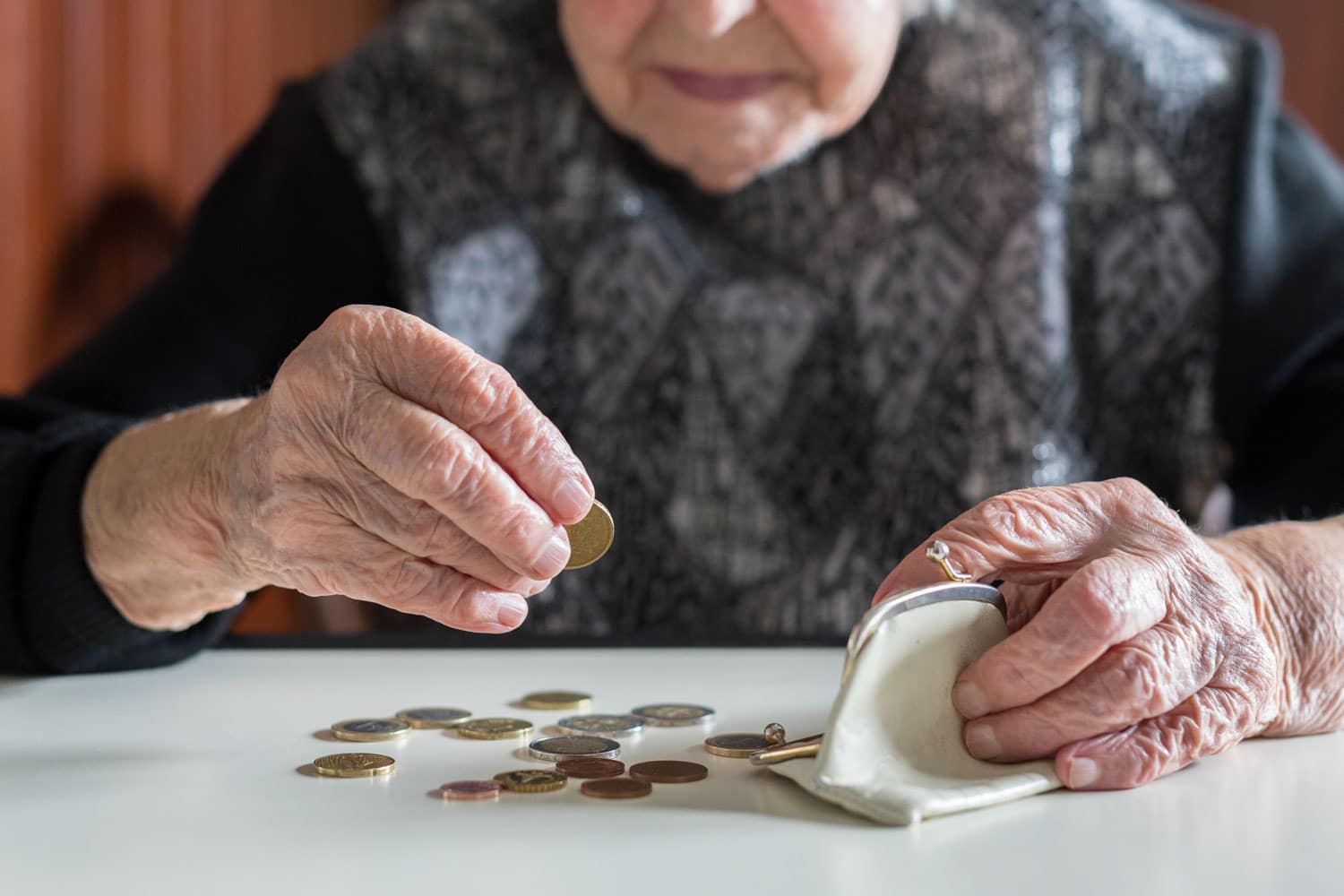 Alte Dame zählt ihr Münzgeld im Portemonnaie