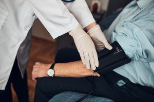 Arzt nimmt Blutdruck bei älterem Mann