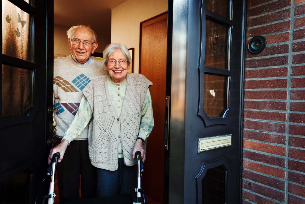 Altes Ehepaar steht in ihrem Hauseingang