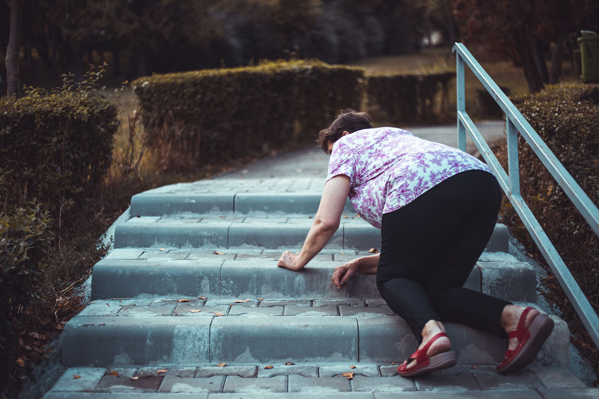 Frau stürzt draussen auf Treppe