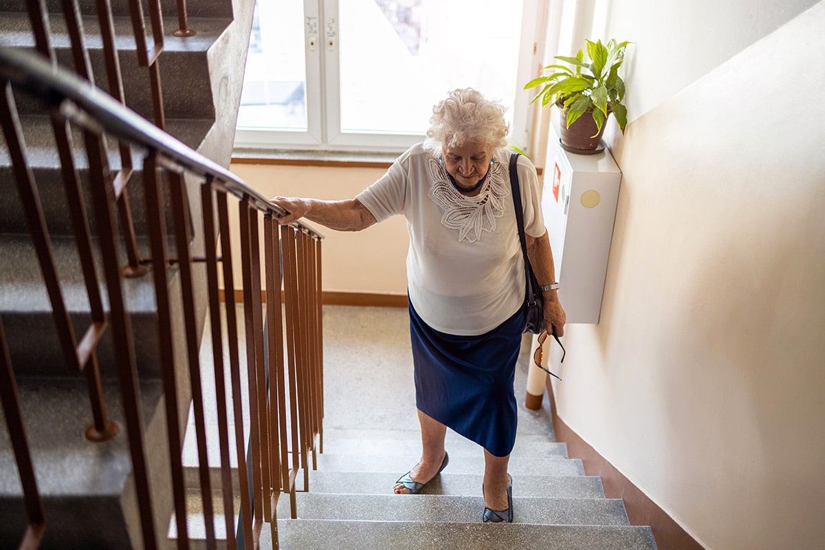 Alte Frau geht die Treppen hoch