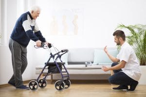 Mann motiviert alten Mann am Rollator